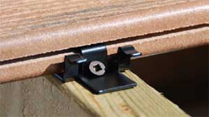 A close up view of a hidden fastener deck clip and grooved composite board